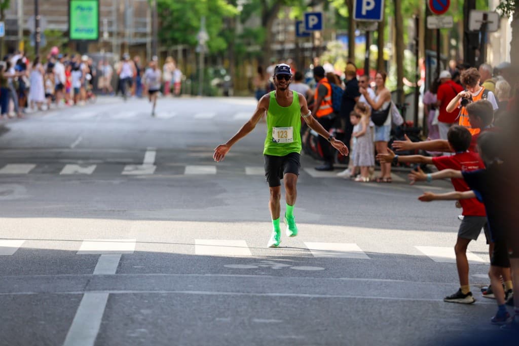 Coureur applaudi par le public sur une course urbaine